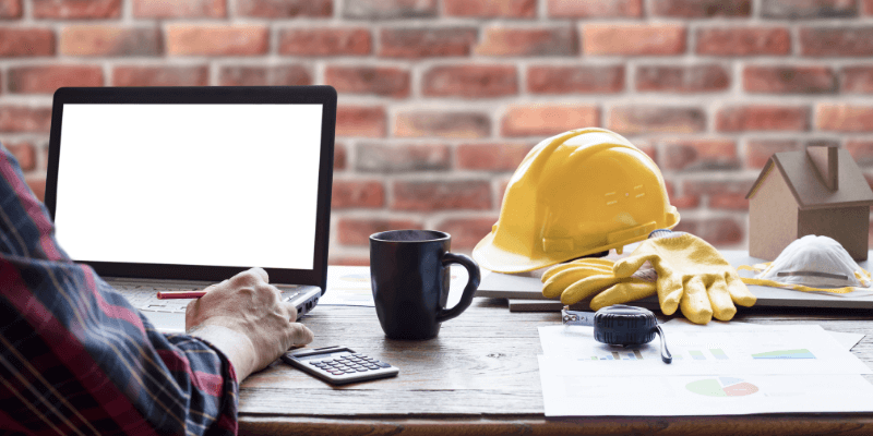 general contractor sitting at a desk working at a computer researching small business funding