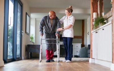 home health care working assists elderly gentleman with walker